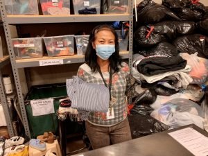 A woman in a face mask sorts clothing donations